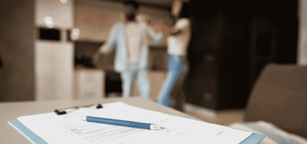 Image of paperwork on table with a couple in the background