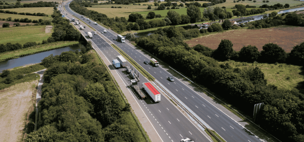 Aerial view directly above a busy UK motorway bridge over a river
